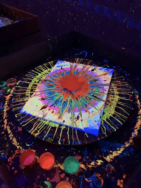 Obraz spin art z farb fluo na obrotowym stole w świetle UV